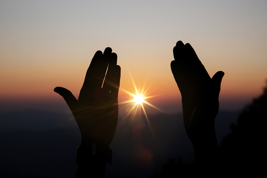 Prière spirituelle, les mains tendus vers le soleil